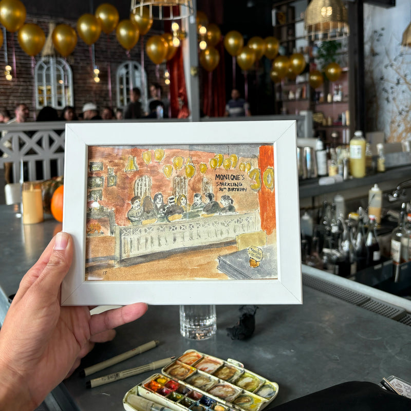 A hand holding a watercolor sketch of a dinner party at a bar